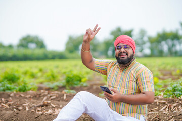 Happy indian farmer using smartphone