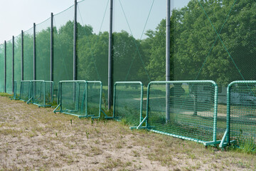 Green Net Fence and Grass Field on Sunny Day