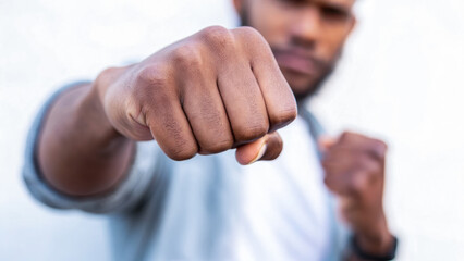 Fototapeta premium Fist raised in a fighting stance, symbolizing strength and determination.