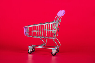 Shopping cart on a solid red background.