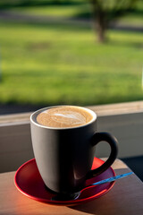 A single cup of coffee with a blurred background