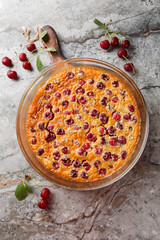 pour-in clafoutis pie with cherries classic french dessert close-up on table. Vertical top view from above
