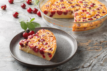 Tender piece of cherry clafoutis pie with fresh berries and vanilla close-up in a plate on the table. Horizontal