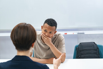 A female staff member interviewing a troubled black man
