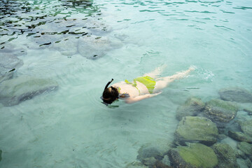 Tourist snorkeling in shallow water exploring the seabed