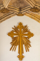 A radiant golden cross with intricate rays and ornate detailing