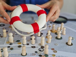 Staff puts lifebuoy on figurine in crowd. Rescue protection and insurance of people concept