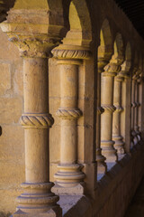 A row of intricately carved stone columns with spiral detailing and arched supports