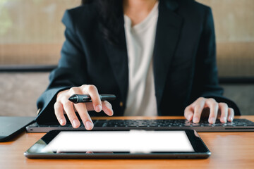 A business professional multitasking with a tablet and laptop, showcasing modern technology in a...
