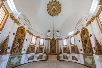 A grand, opulent interior with a central altar surrounded by ornate altarpieces