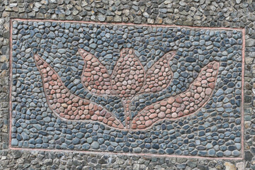 Pebble Mosaic of Stylized Flower on Stone Wall