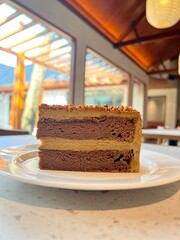 A slice of mocha cake with multi-layered mocha flavored mousse, topped with mixed of crumbled nuts...