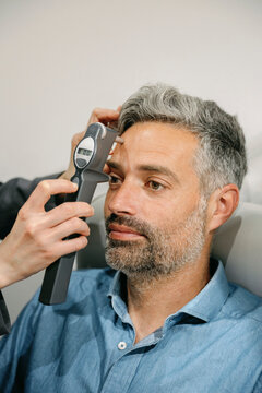Patient receiving an eye pressure test using a modern handheld tonometer