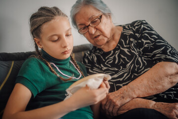 Grandmother teaching granddaughter cross-stitch embroidery skills