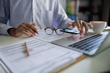 asian businessman checking business contract and using laptop working and meeting online with business group at home office, working at home concept