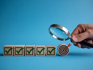 Wooden cubes with green check marks and a target with an arrow examined by a magnifying glass image