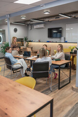 Meeting women collaboration, office: group meets discussing project today, laptops & decor on table.