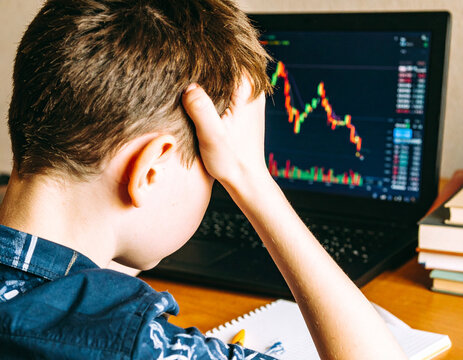 Frustrated Young Investor with Declining Stock Chart on Laptop, Boy Stressed by Investment Losses Watching Market Volatility