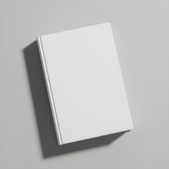 Mockup. A blank, hardcover book lies flat on a light gray surface, casting a soft shadow to the right.