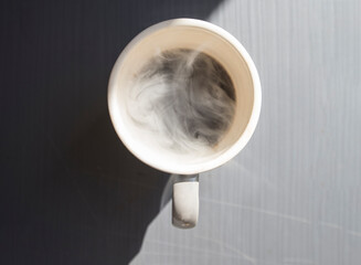 Coffee cup with steam on the table in the morning.