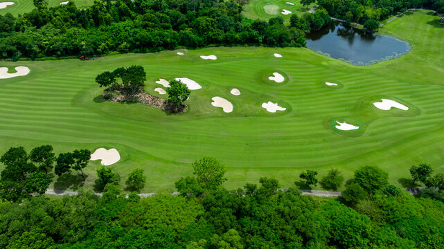 Aerial top view golf course with lush greens, green fairway and sand bunker, Golf course green grass and trees fairway and putting green, Beautiful golf course.