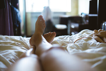Women's legs in the morning in bed