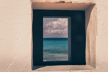 Slave hut window with blue sky and ocean. These huts were created in the late 1700s.