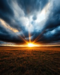 The sun casting dramatic rays of light through storm clouds over an open prairie