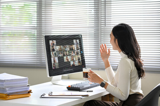 Businesswoman joins a virtual meeting on her desktop computer in a bright office