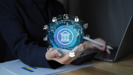 businesswoman’s hand holding a glowing banking icon, symbolizing global financial technology, digital economy, and smart investment strategies.and financial technology in business.