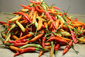 Colorful assortment of fresh chili peppers in red, orange, and green, perfect for spicy culinary...