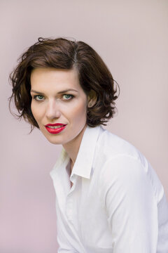 Studio portrait of beautiful young woman with blue eyes and short brown hair
