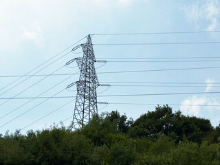 Electric transmission tower in rural landscape with clear sky