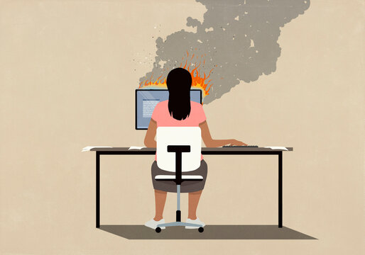 Woman sitting at desk working at computer on fire

