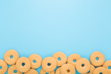 Circle shape of dry cookies on light blue table background. Pastel color. Closeup. Sweet snack....