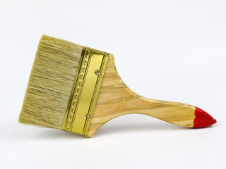 A wide, clean paint brush with wooden handle on a white background.