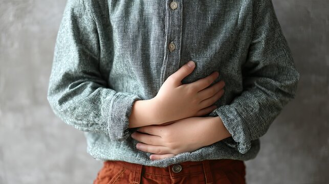 Child rubbing his belly, showing signs of indigestion. 