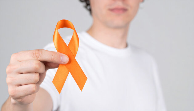 Hand holding orange awareness ribbon. Leukemia, multiple sclerosis, gun violence prevention