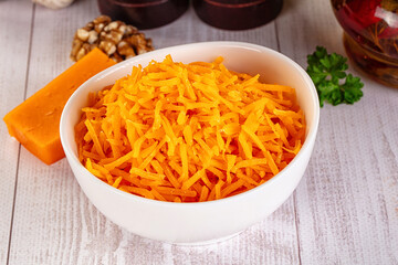 Yellow shredded cheddar cheese in the bowl