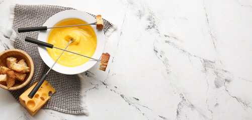 Sticks with croutons dipped into cheese fondue on light background