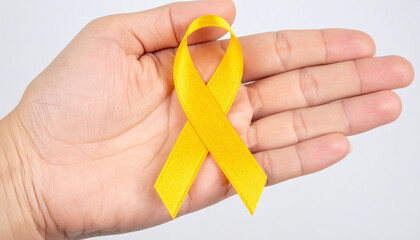 Hand holding yellow awareness ribbon. Support for military troops, suicide prevention awareness