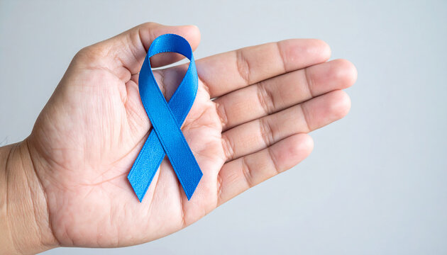 Hand holding blue awareness ribbon. Child abuse prevention, colon cancer, human trafficking