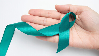 Hand holding teal awareness ribbon. Ovarian Cancer Awareness. Sexual Assault Awareness