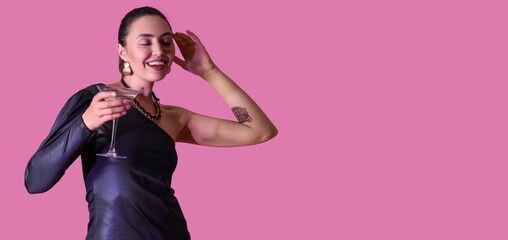Beautiful young woman with martini on magenta background with space for text