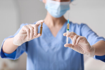 Nurse with ampule and syringe in clinic, closeup