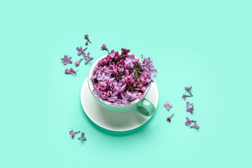 Lilac flowers in cup on turquoise background
