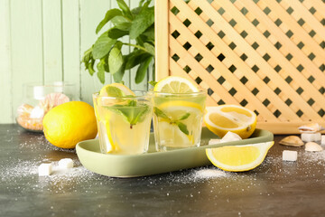 Glasses with fresh lemonade on black table