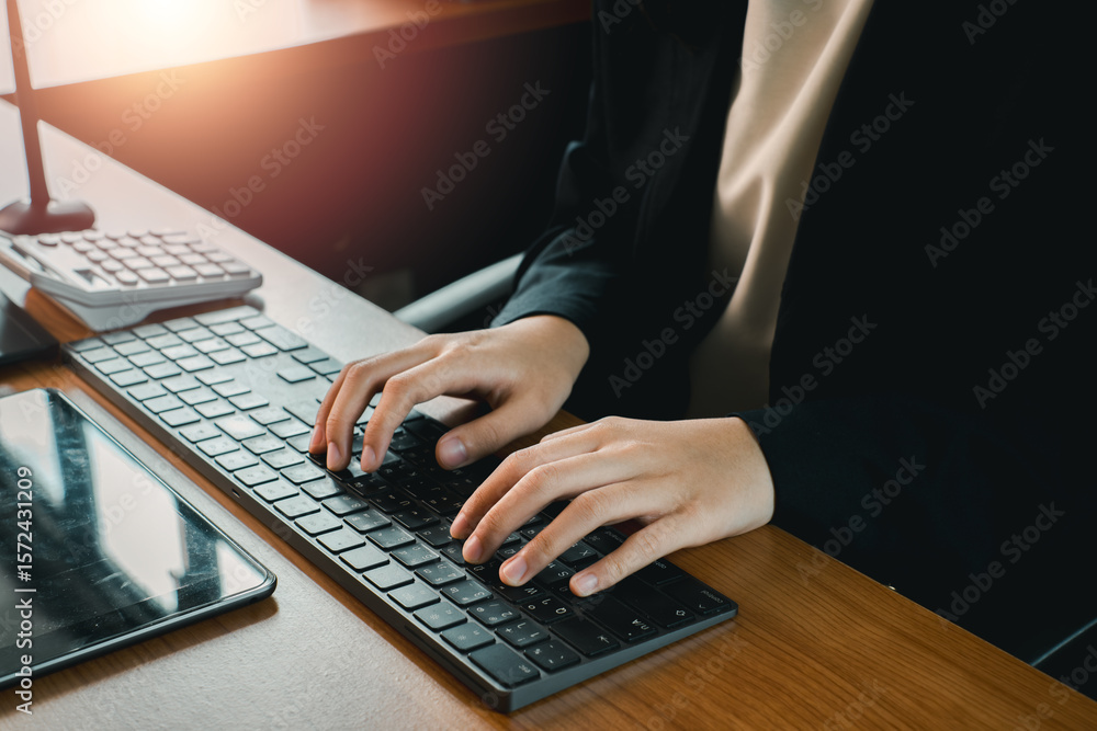 Aufkleber close-up of hands typing on a keyboard in a modern office environment with sunlight streaming in.
