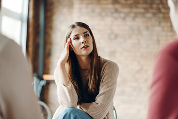 Young woman thinking during a therapy session with psychologists