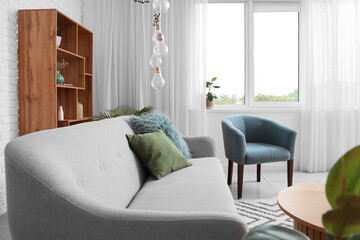 Comfortable armchair and sofa in living room